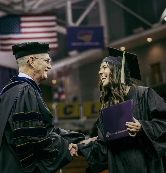 UNI student shaking hands with President Nook at Commencement