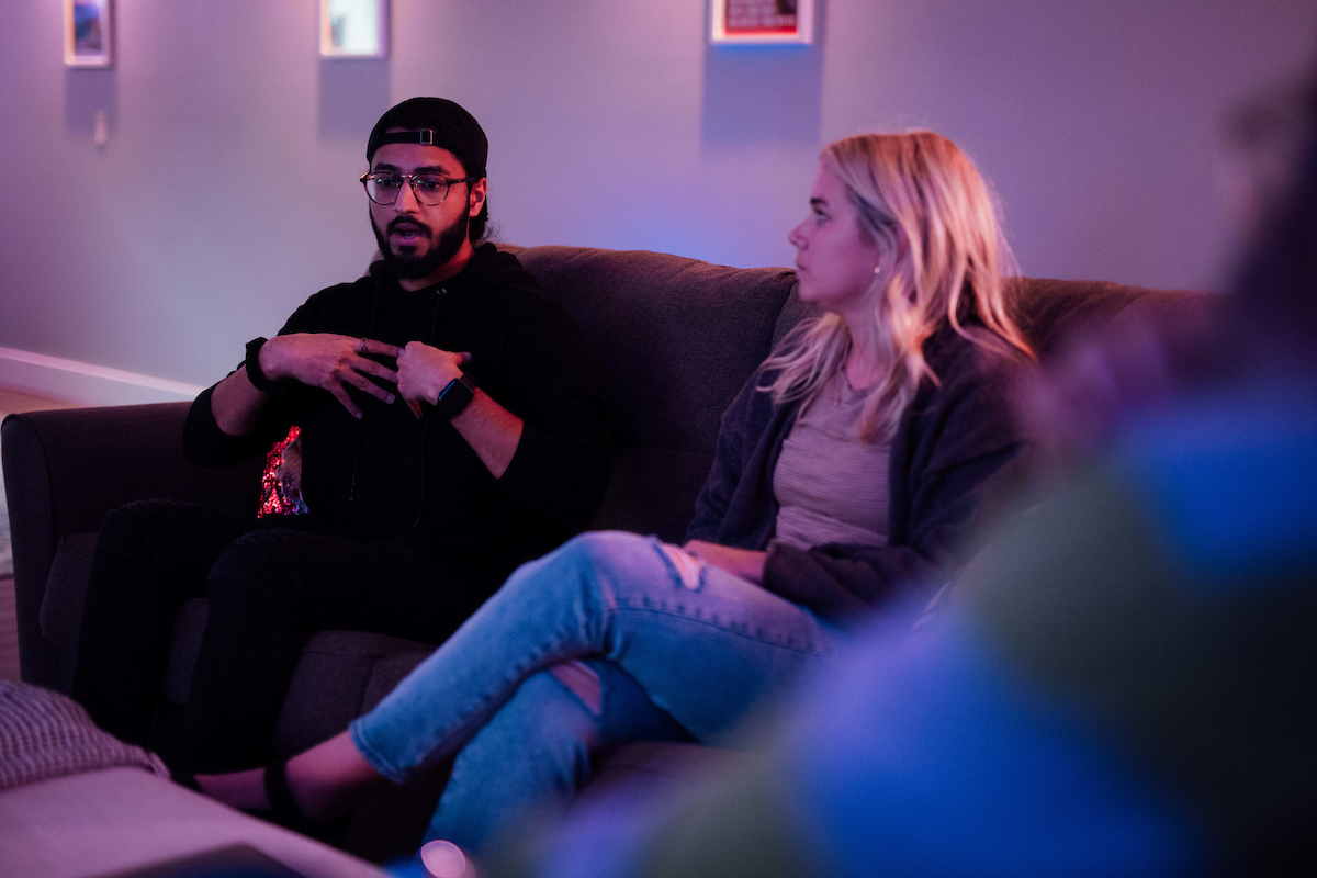 Man talking on couch next to woman