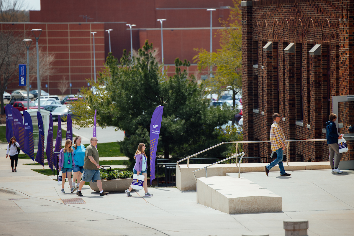 Family walking to Admissions Welcome Center on UNI campus