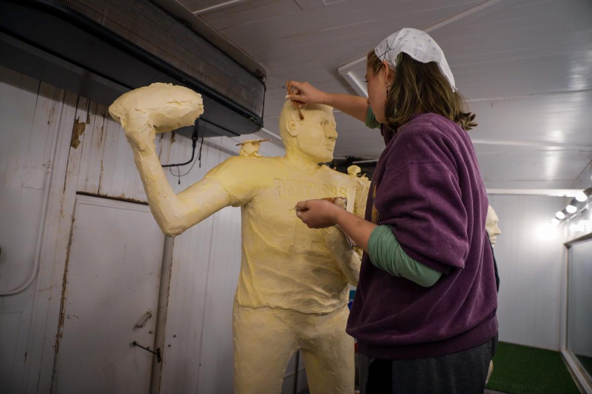 Butter sculpting apprentice Hannah Pratt works on Kurt Warner sculpture