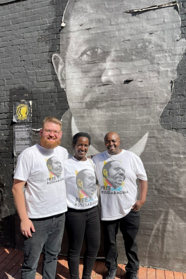 Isaac Campbell with Paul Rusesabagina family in front of mural