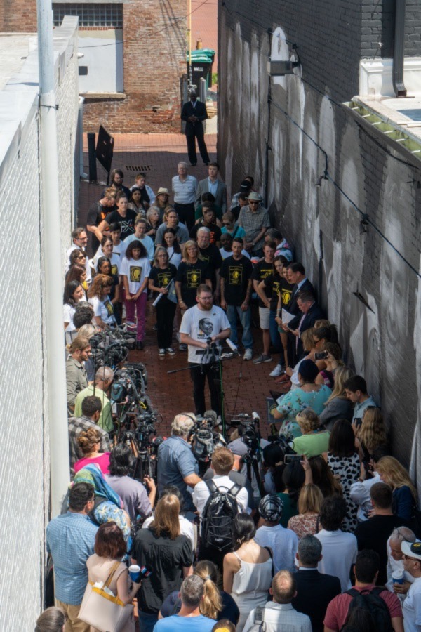 Isaac Campbell talking to media in front of mural