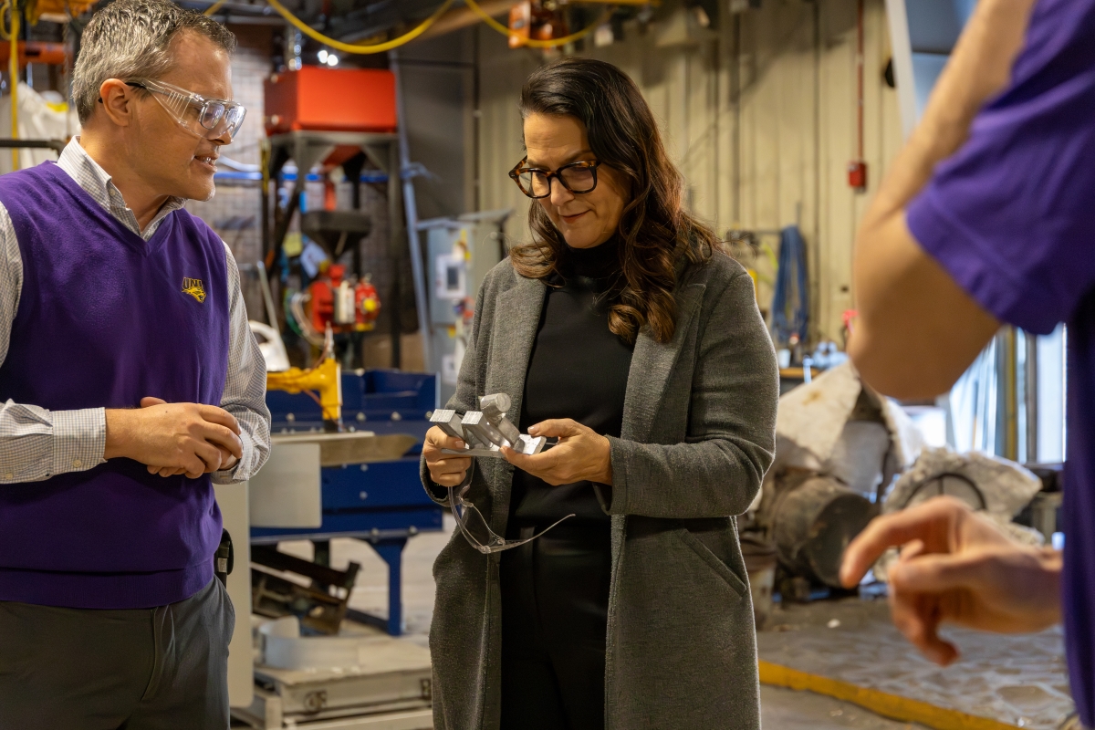 Lt. Gov. Cournoyer in AEB looking at metal UNI memento