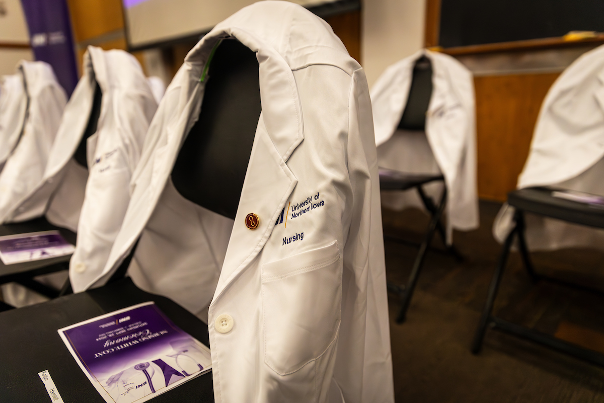 UNI white coat draped over chair