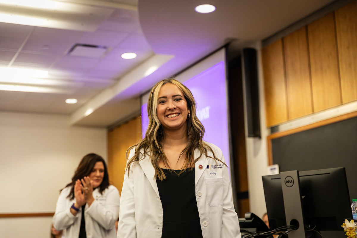 UNI student poses in white coat