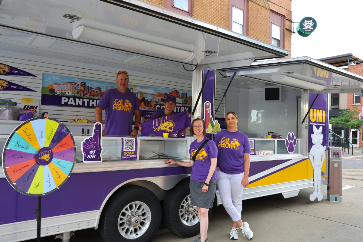 UNI employees wearing Cat Pack t-shirts getting ready for bikers at UNI trailer