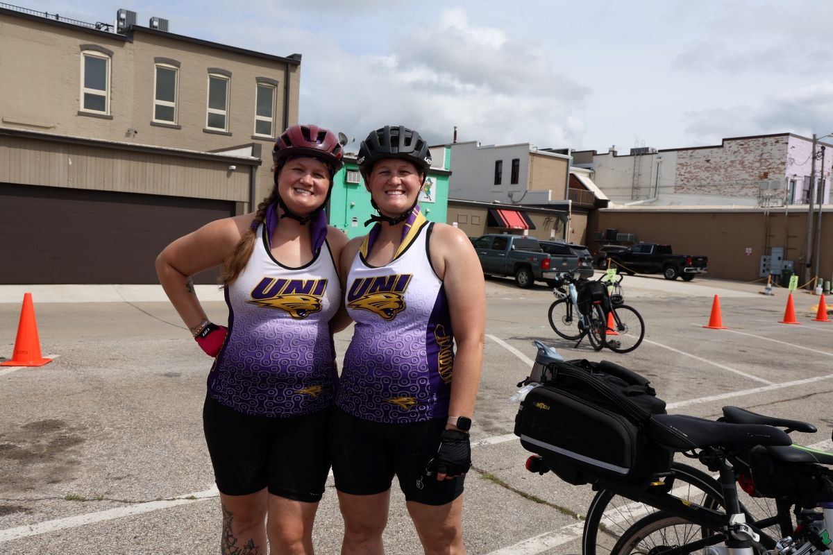 Two bikers wearing matching UNI outfits