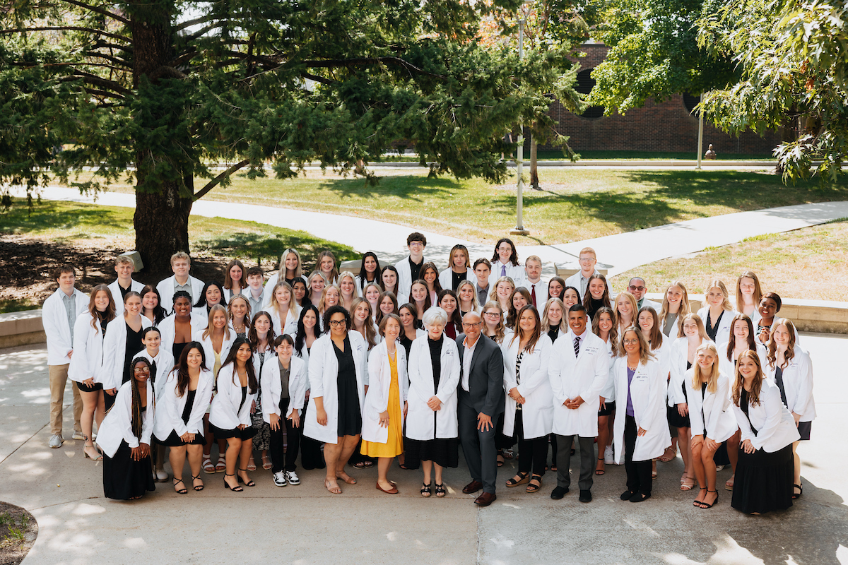 Nursing students and faculty in white coats
