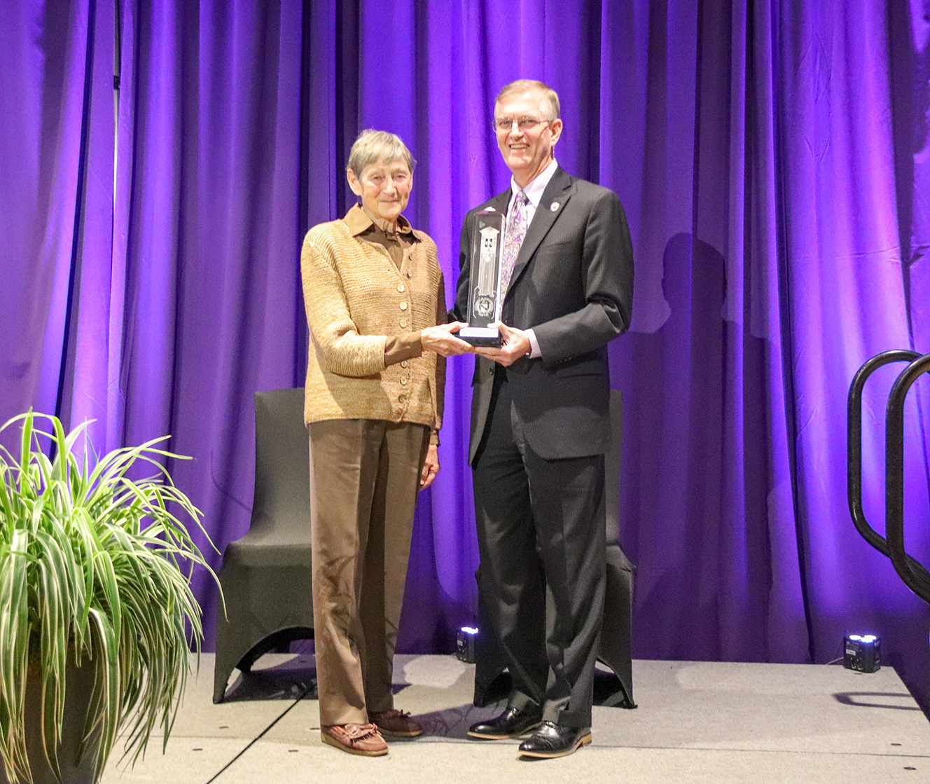 Cathy Irvine receives an award from UNI President Mark Nook