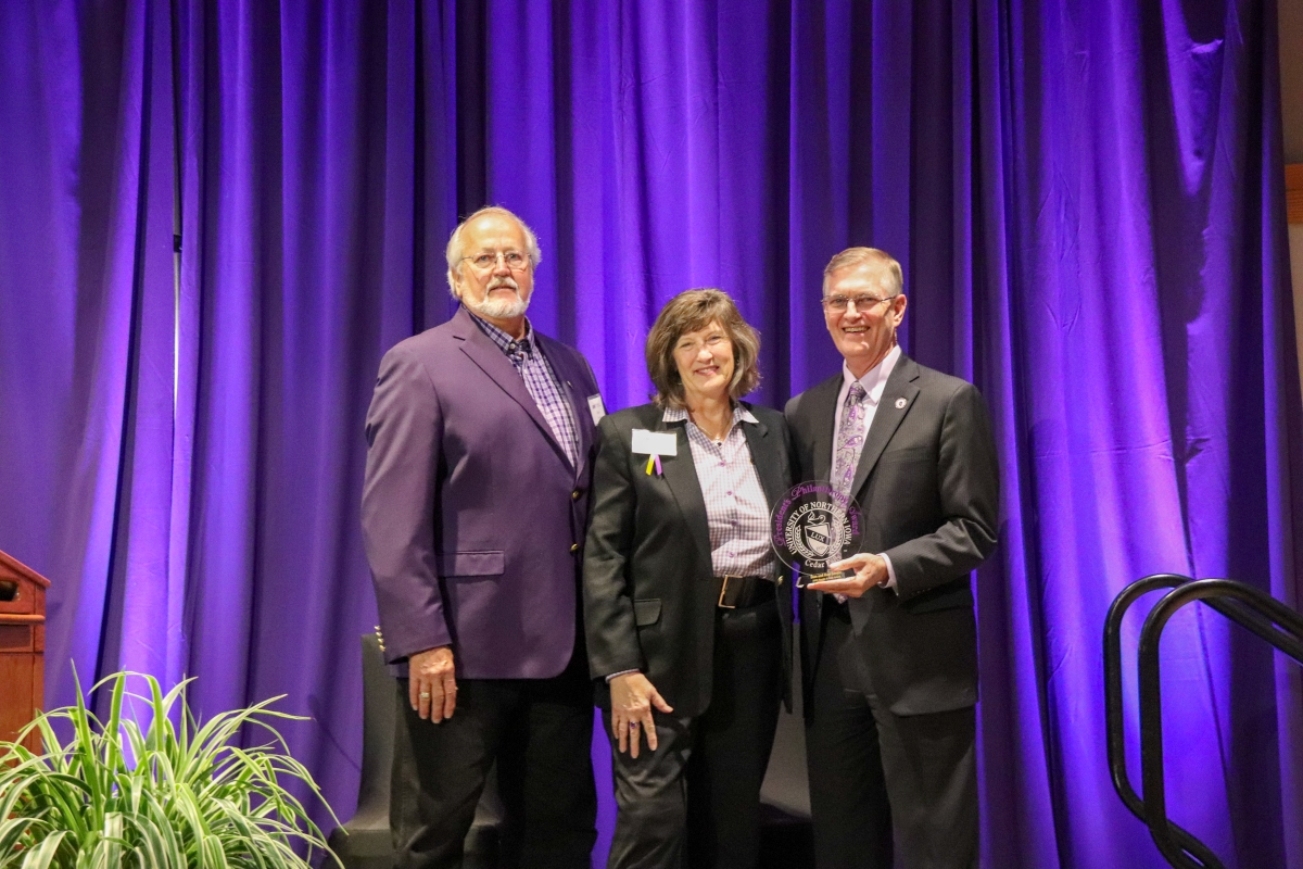 Stan and Rose Lorenz receive the Purple and Gold award from President Mark Nook