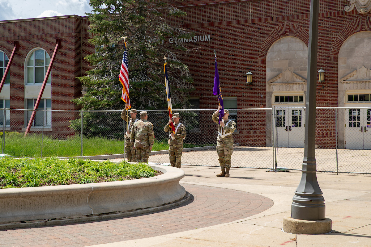 ROTC hoisting flags in front of the West Gym