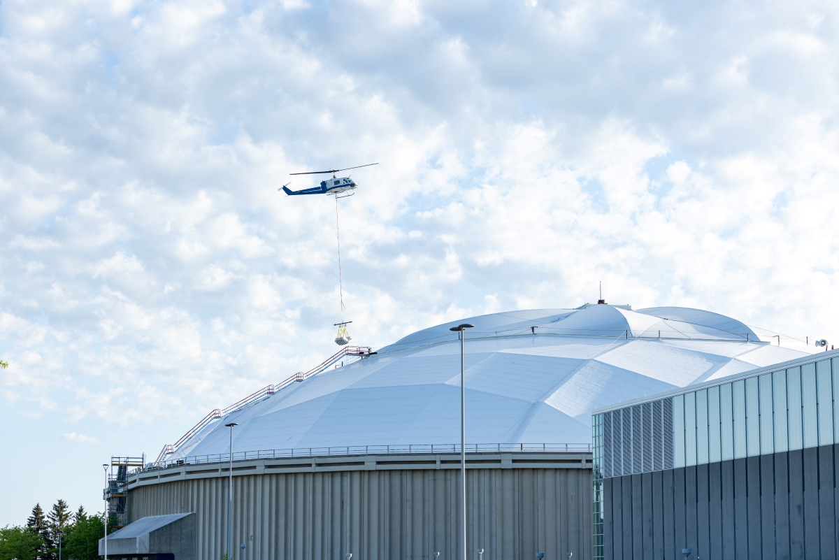 Helicopter lowering materials onto UNI-Dome
