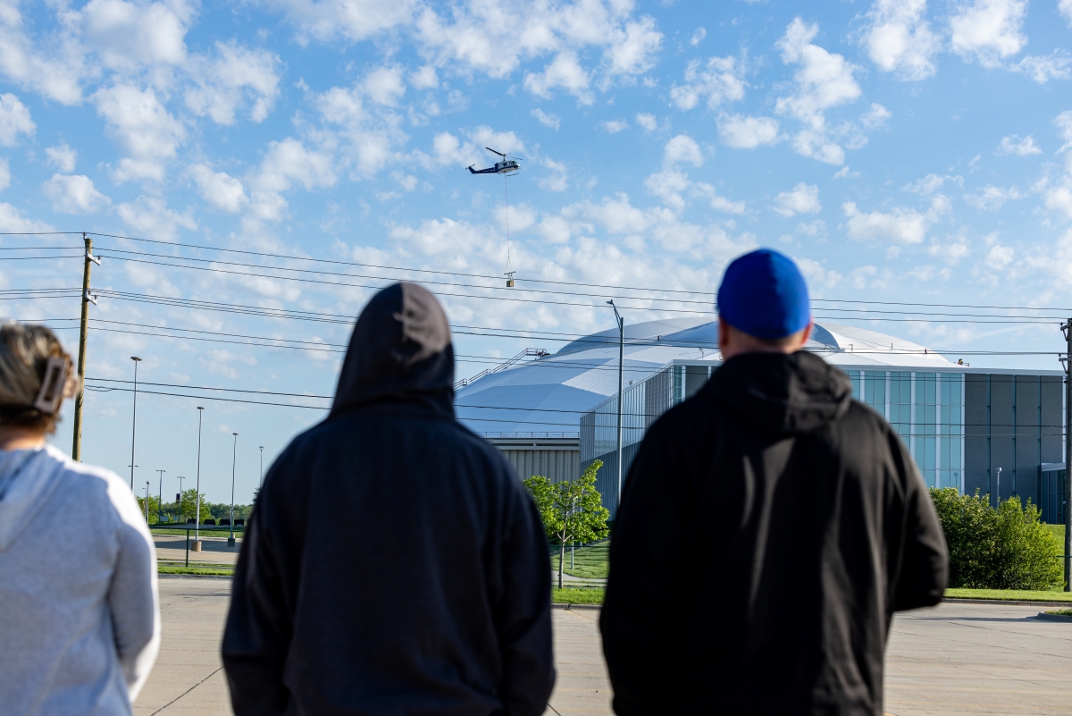Onlookers watch helicopter fly over UNI-Dome