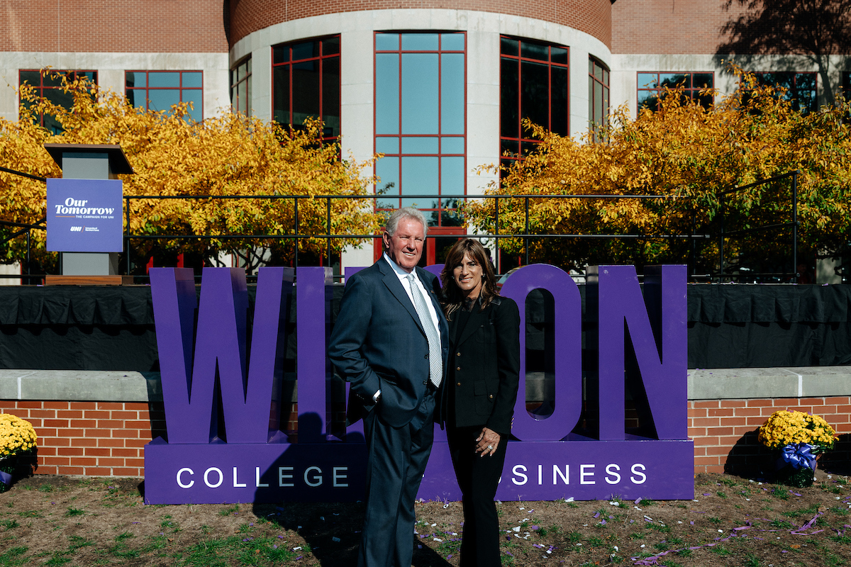 David and Holly Wilson standing in front of Wilson College of Business sign