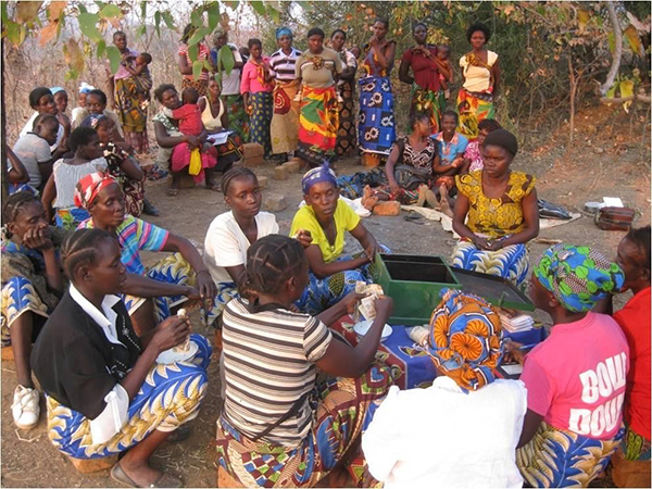 A group of women in Zambia gathers to disperse loans from a communal savings.