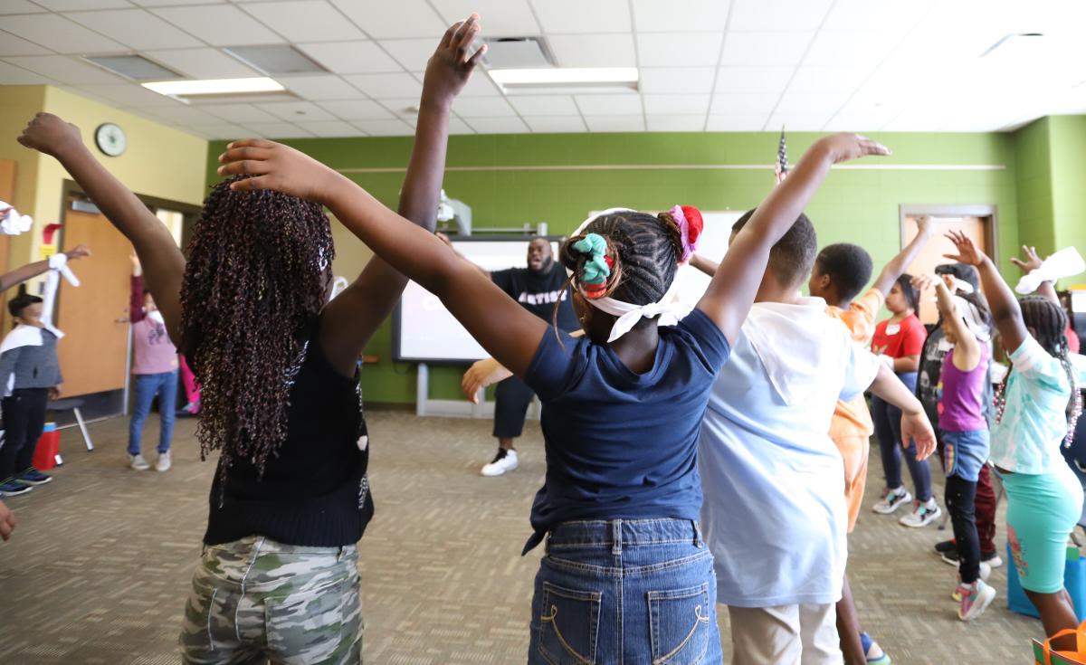 Teacher leads students in dance