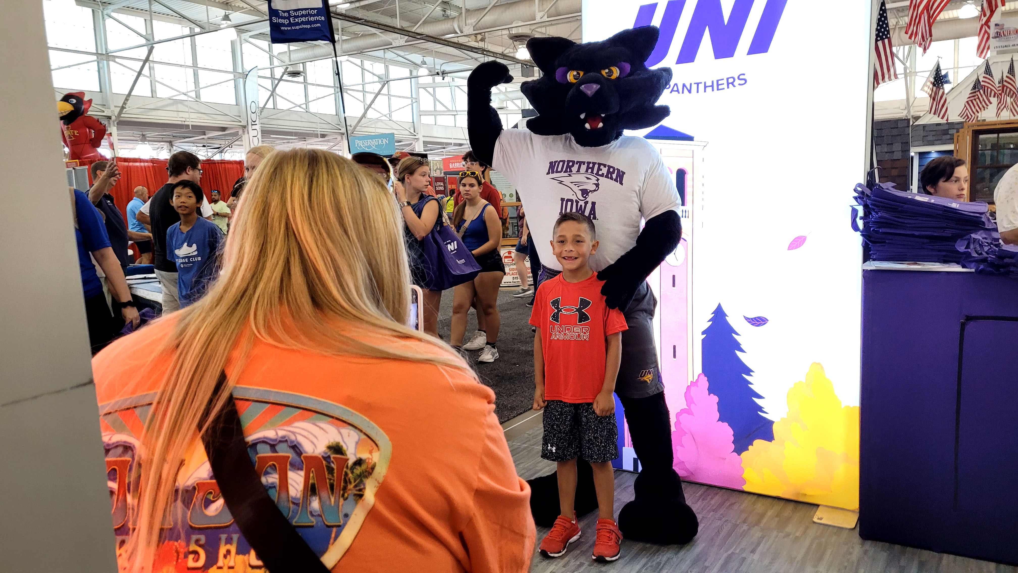 Child posing with TC the mascot at the Iowa State Fair