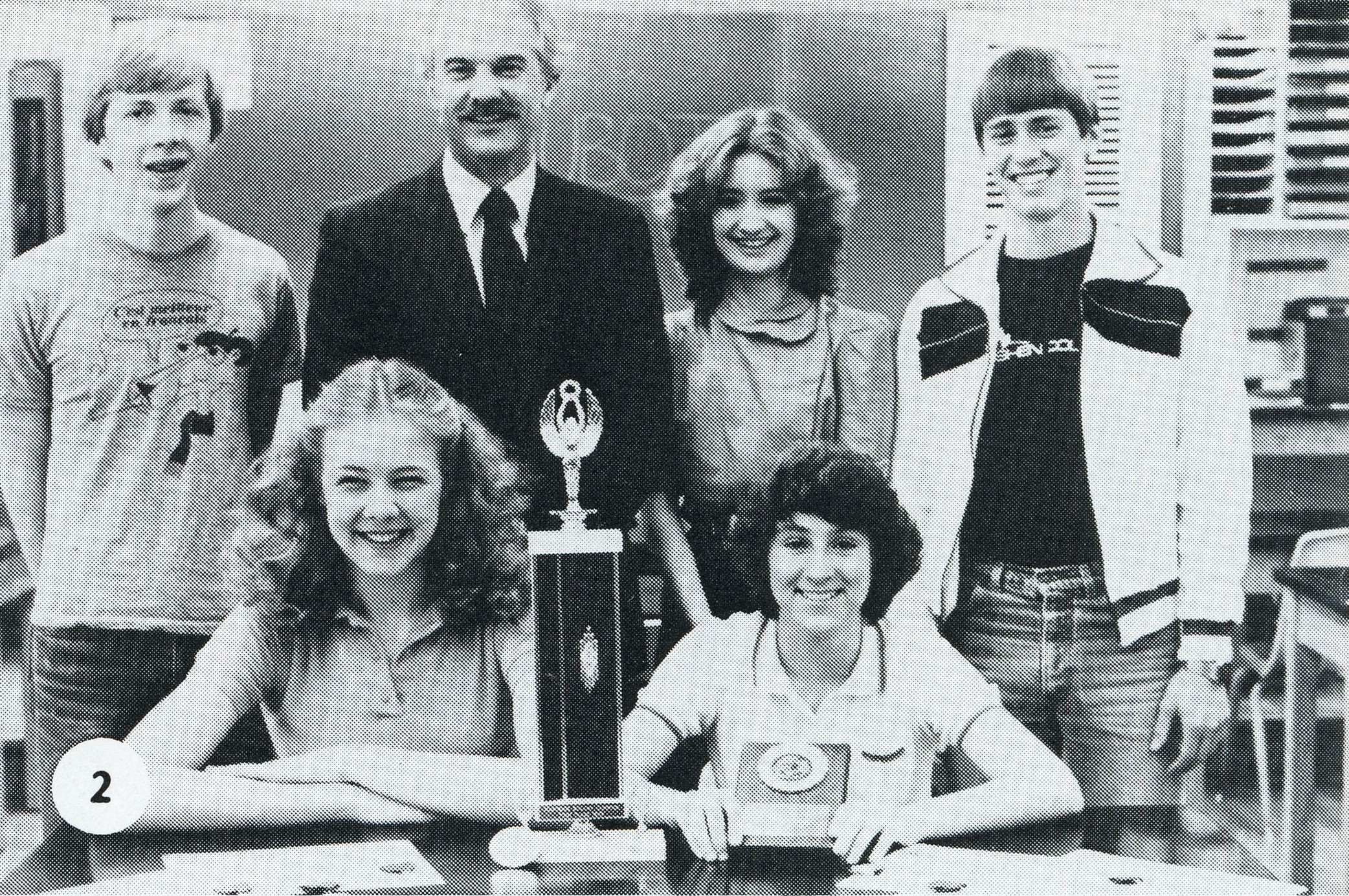 Jim Kelly with students and a trophy