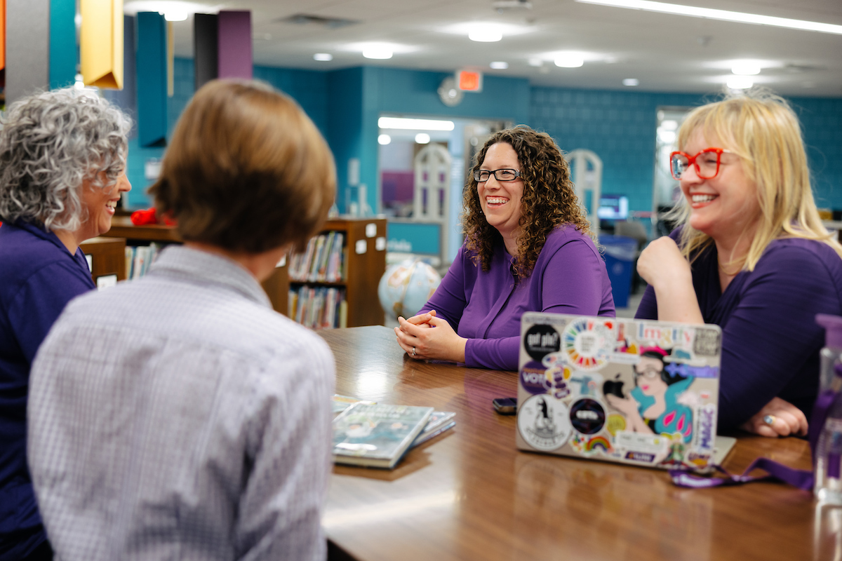 Two deans, the TEACH Studio coordinator and educational technology faculty gathered at a high table talking in TEACH Studio. 