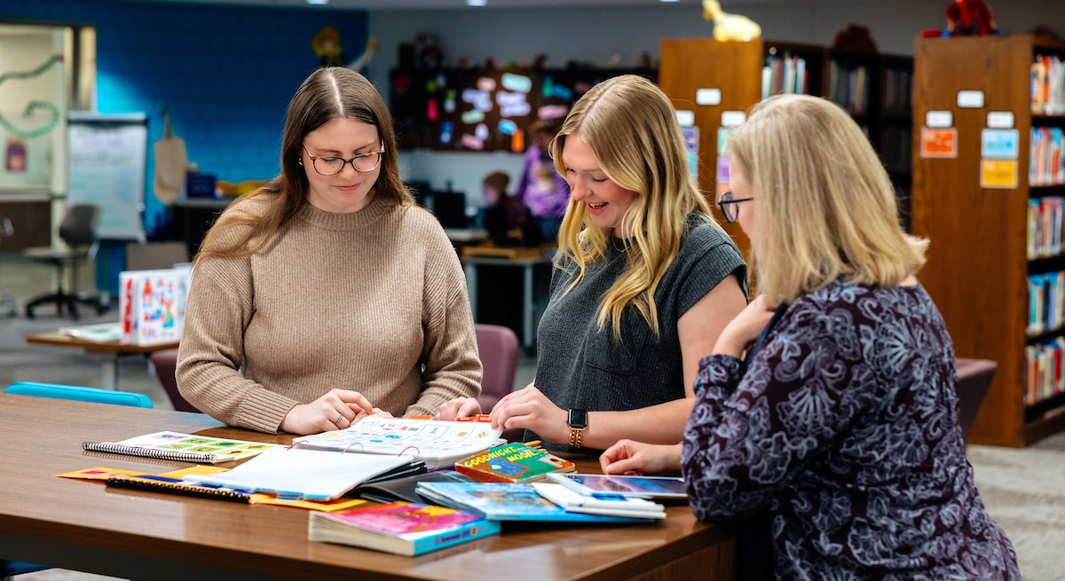 Special education students reviewing materials with professor Sarah Vander Zanden i