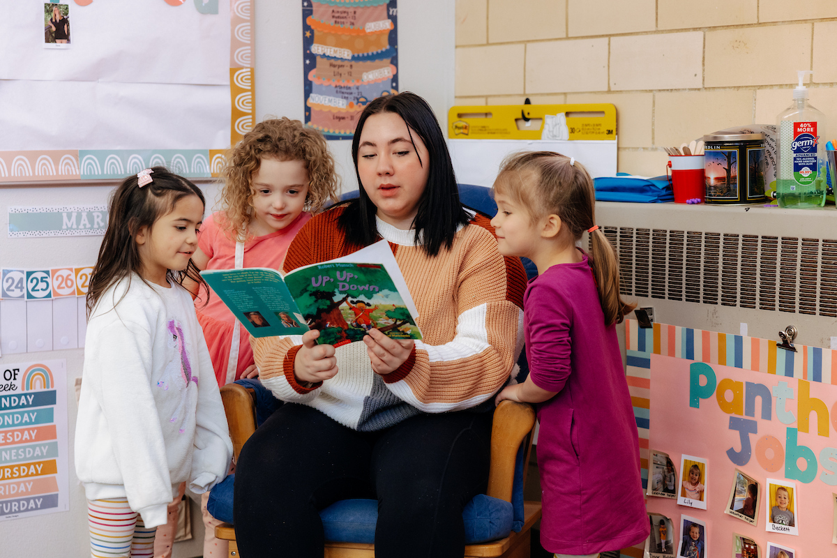 Student teacher reading to young students