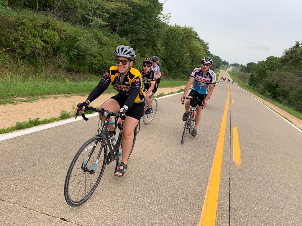 Bikers on RAGBRAI including one woman wearing a UNI jersey