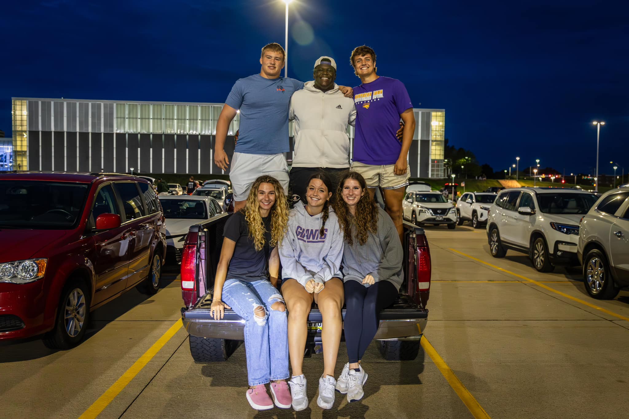 A group of students gather in the bed of a pickup to watch Fireworks Over the Dome