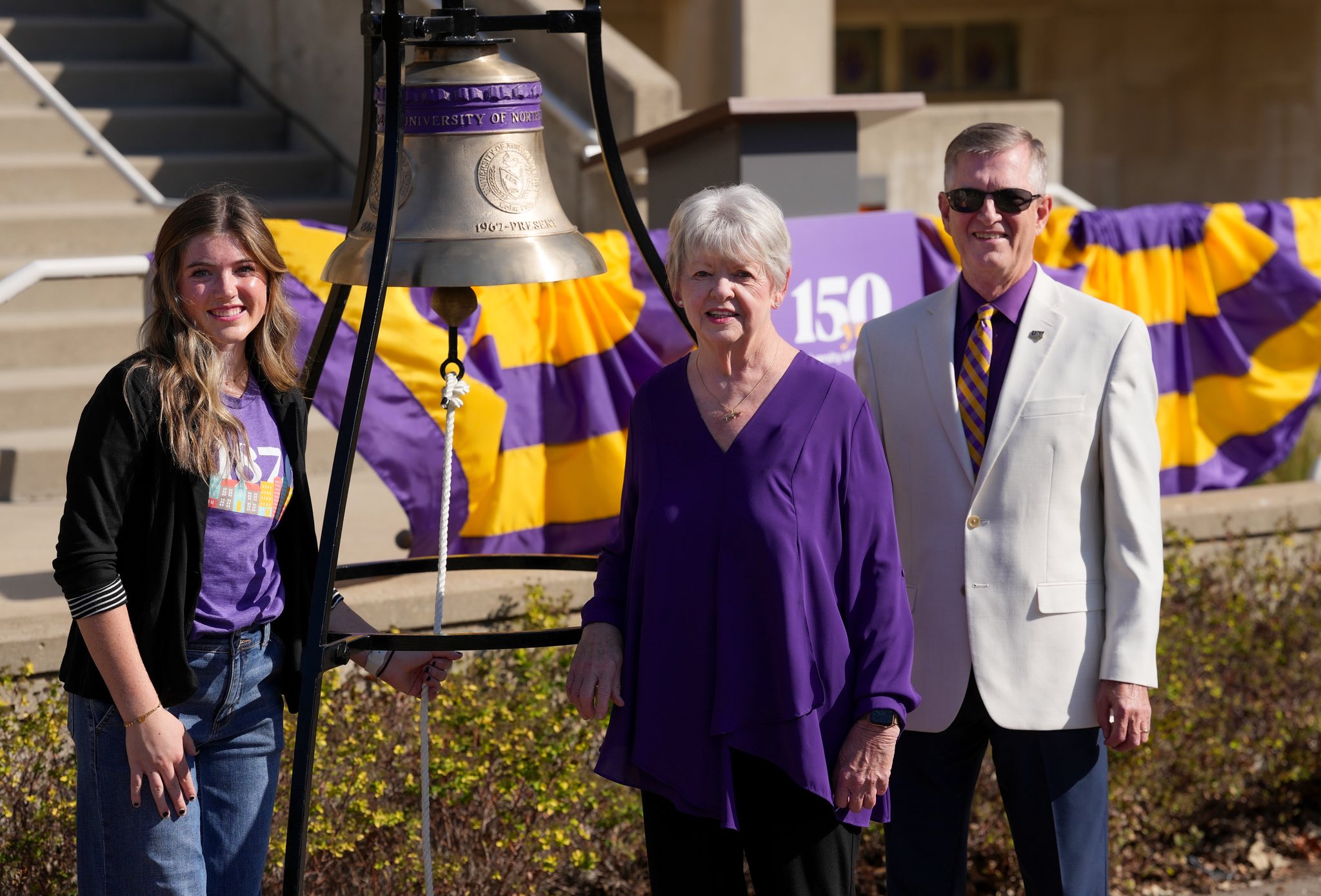 Ali Webster, Noreen Hermansen, and President Mark Nook with Sesquicentennial Bell