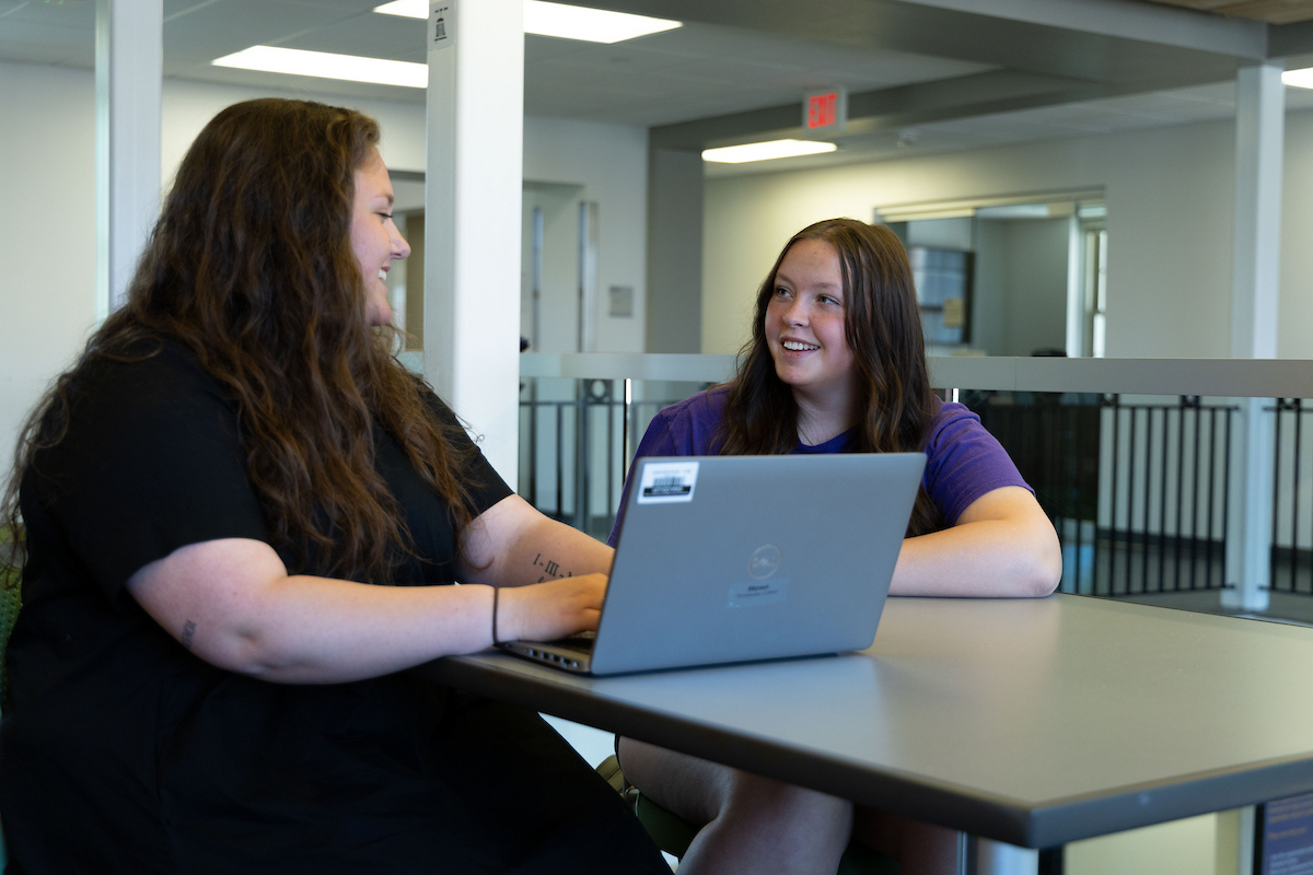 Jana Baker with an advisor working on laptop
