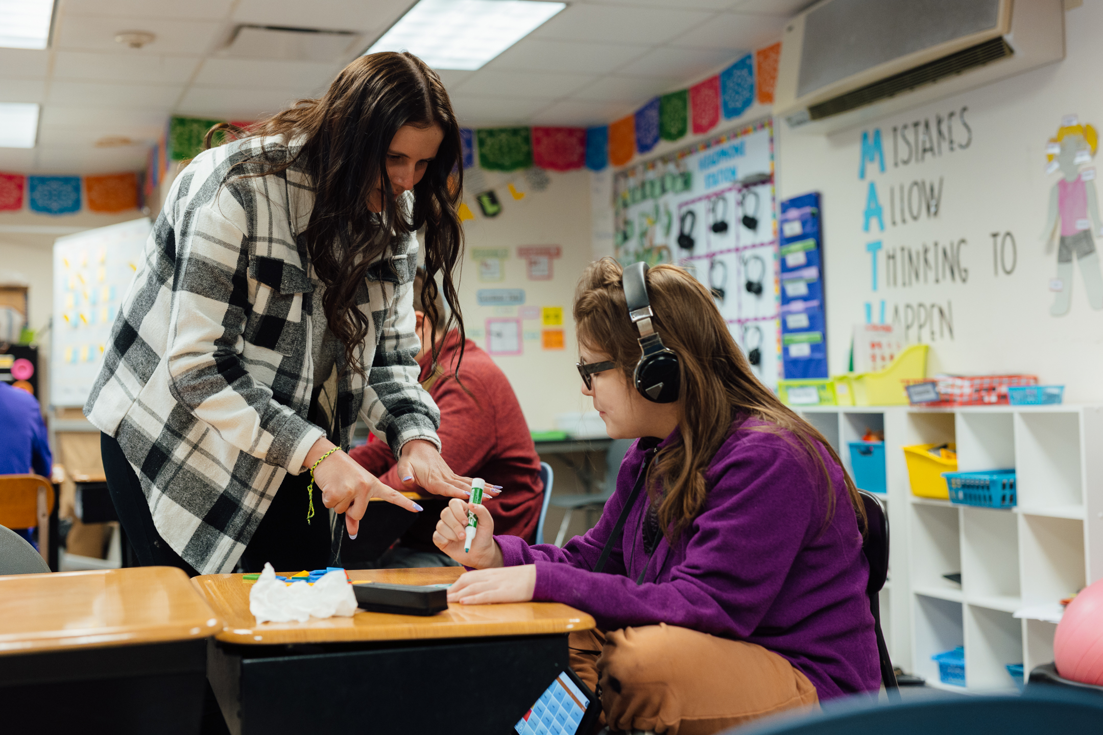 Teacher education student working with young student in the classroom
