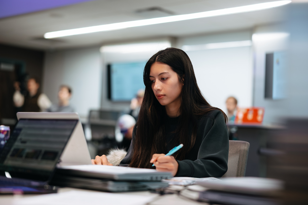 Business student writing at desk