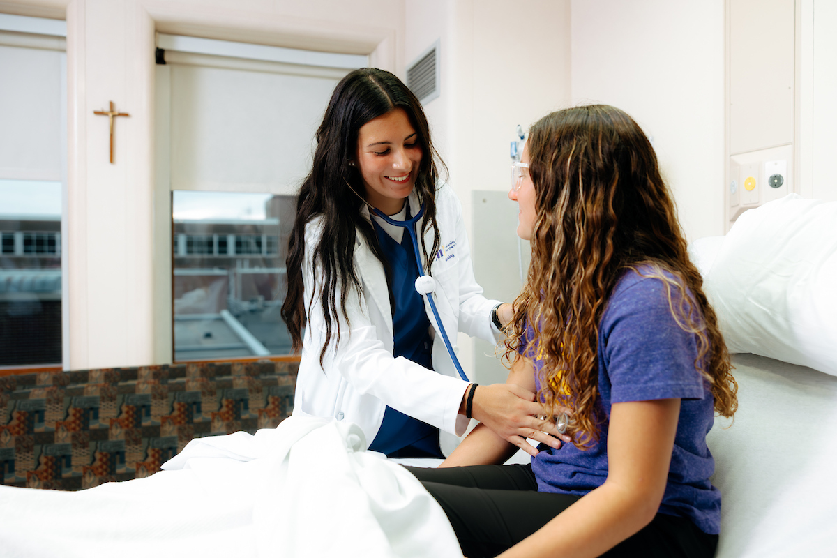 Nursing student working with patient
