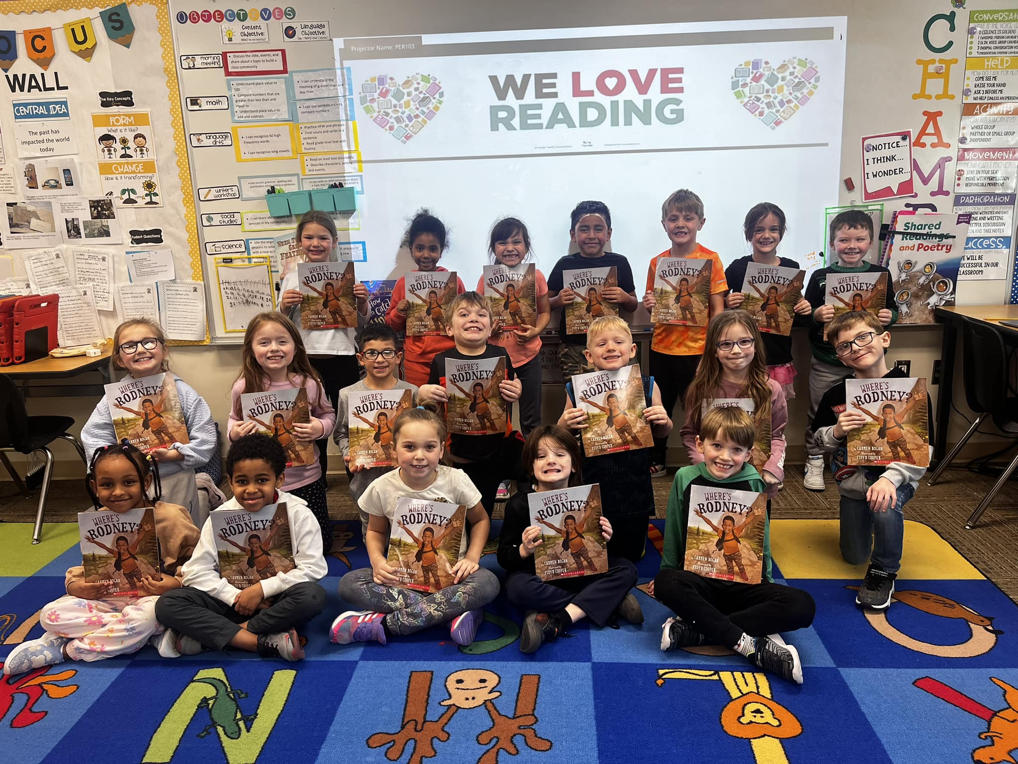 Students holding up "Where's Rodney?" book for African American Read-In