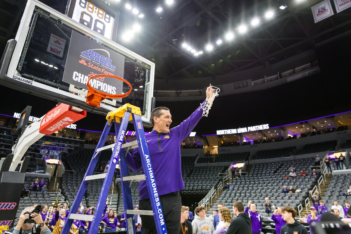 Coach Ben Jacobson cutting basketball hoop at Arch Madness championship