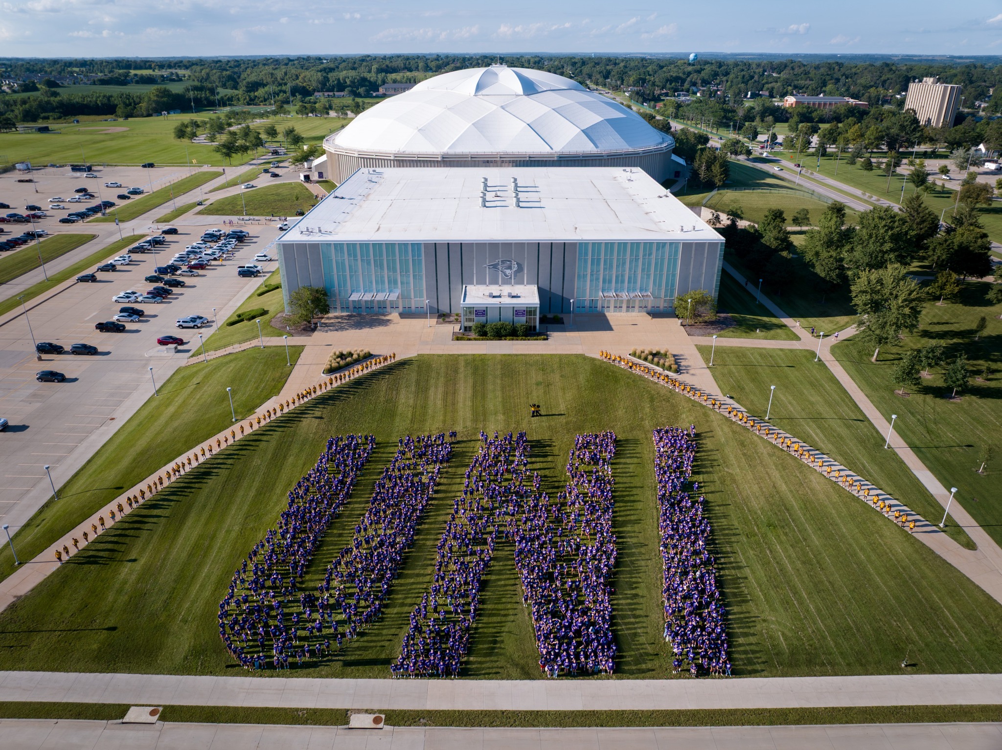 Incoming UNI students pose in the shape of the U-N-I letters in front of the McLeod Center