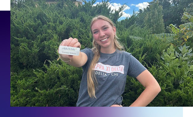 Courtney Schreier poses with Alpha Xi Delta name badge