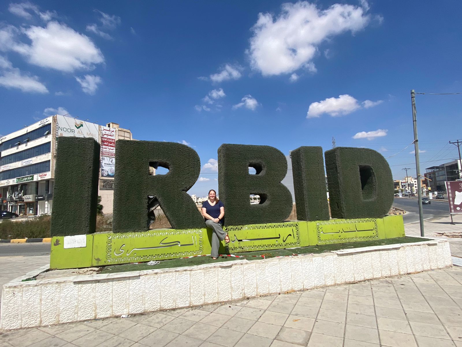 Elizabeth Rench in front of sign that says Irbid