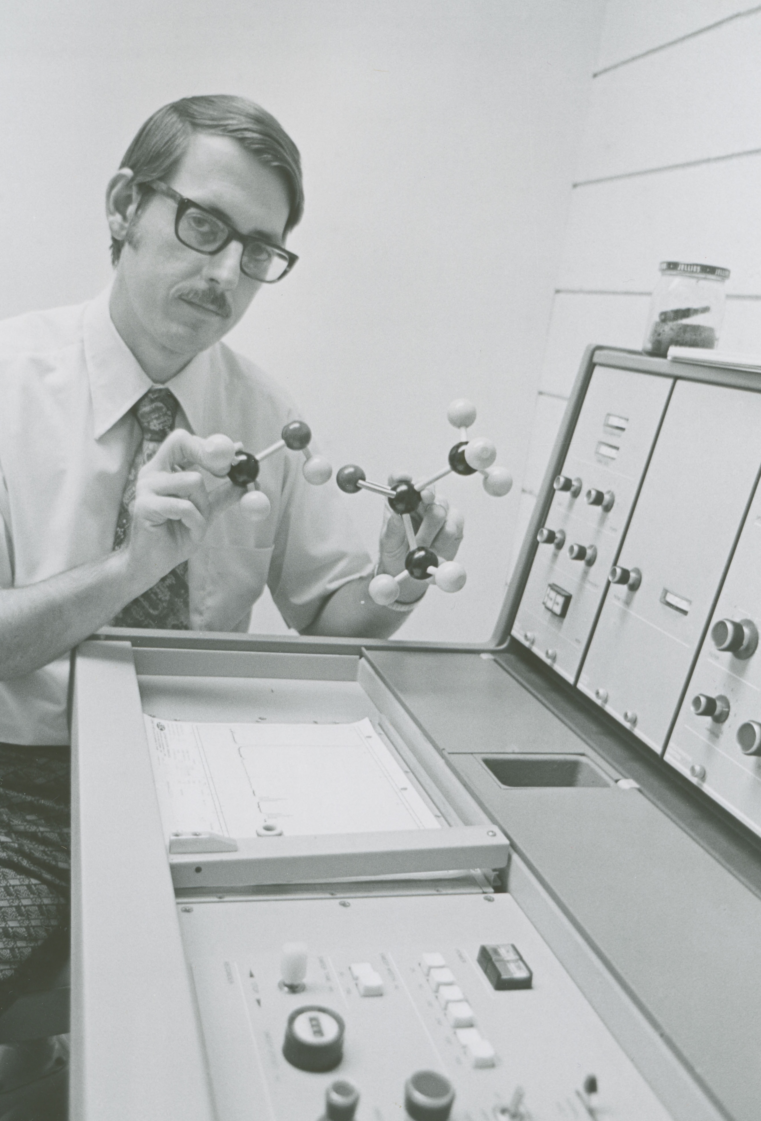 Summer 1974, Paul Rider manipulating a chemistry molecular model in front of a machine.