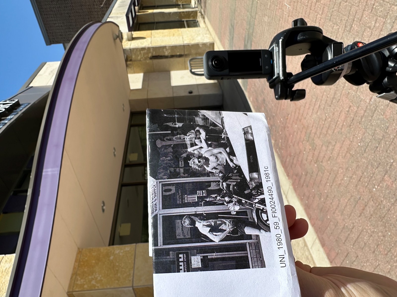 Zach Rogers holding historic image of College Hill up to camera
