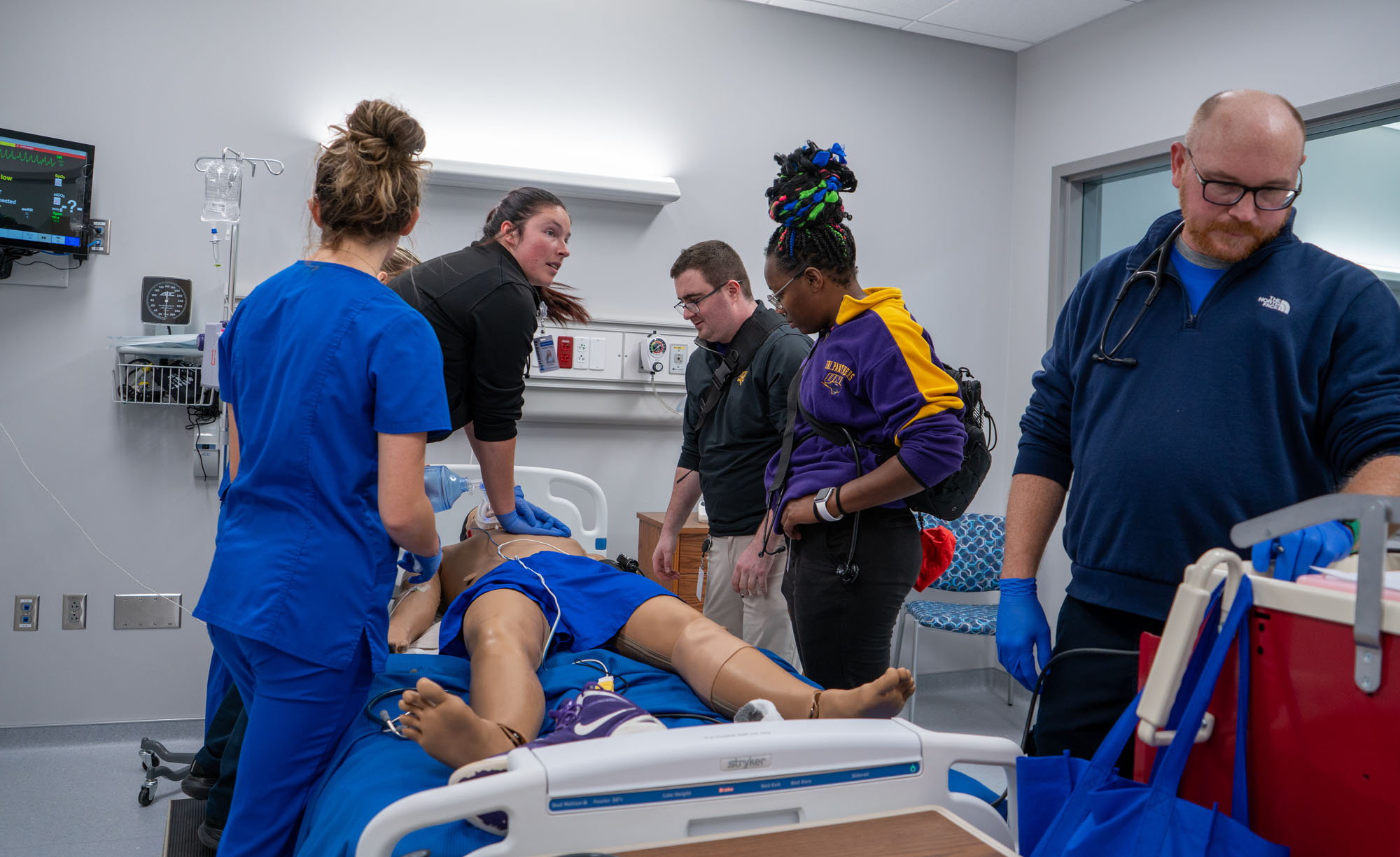 Nursing students, EMT students and athletic training students all gather to help the simulated patient in the ER.
