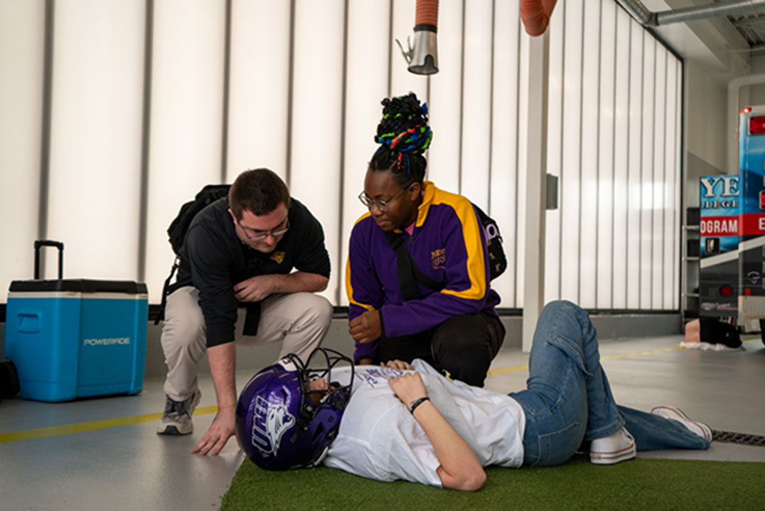 UNI athletic training students help a simulated patient.
