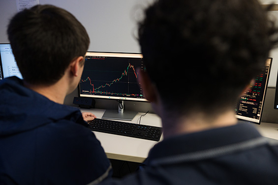 Two students review stock market data on a computer