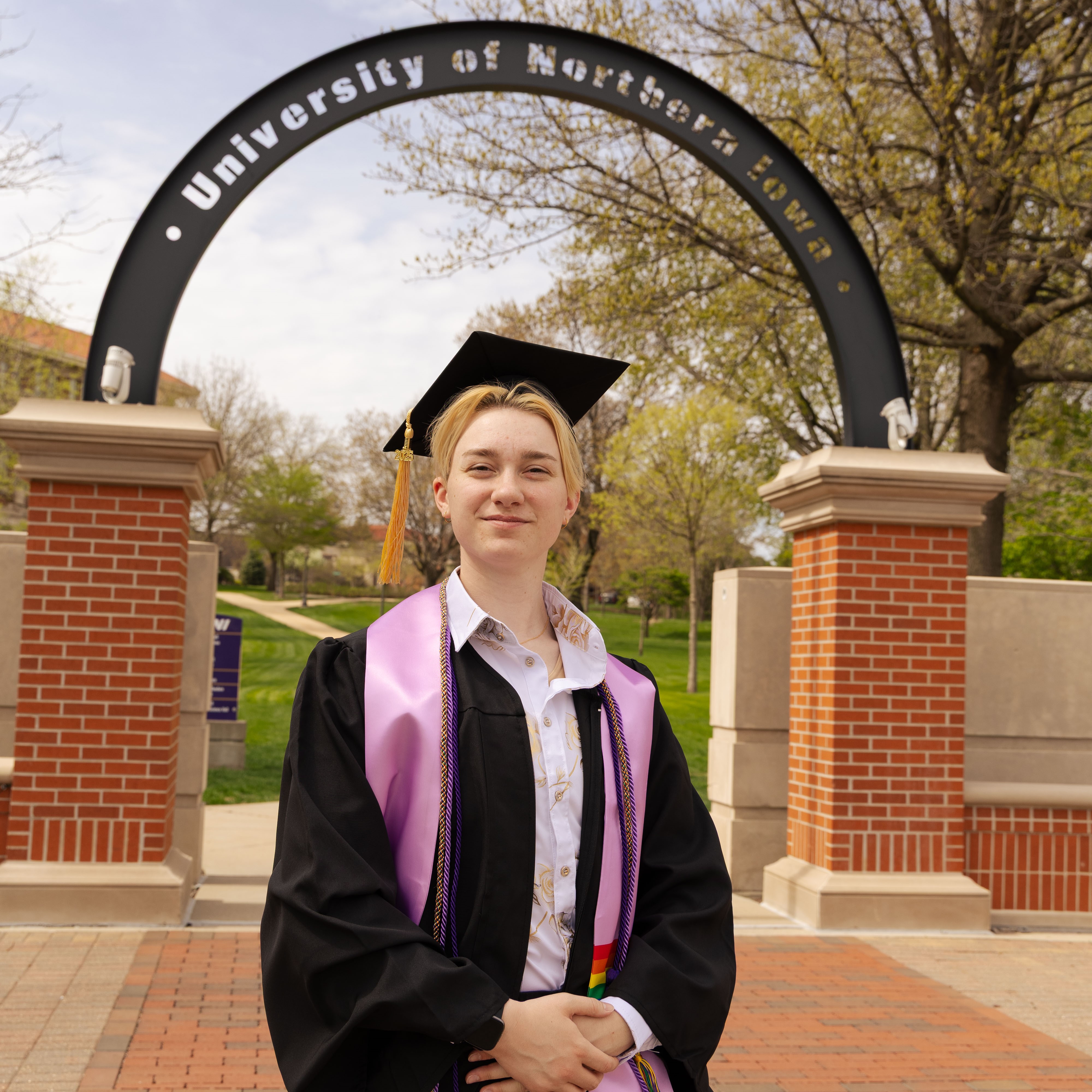 Kai Smith in graduation cap and gown on UNI campus