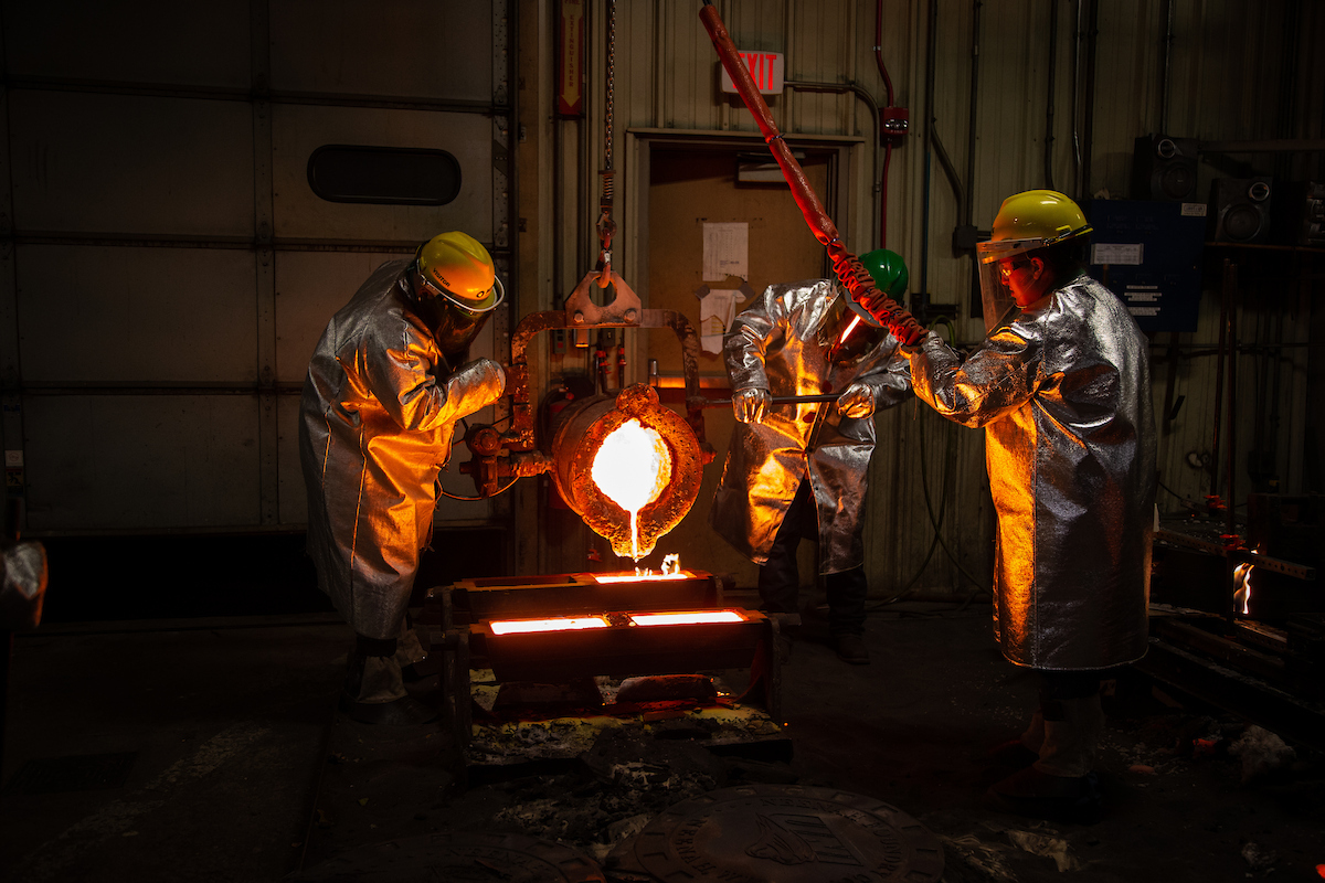 Foundry workers pouring hot metal