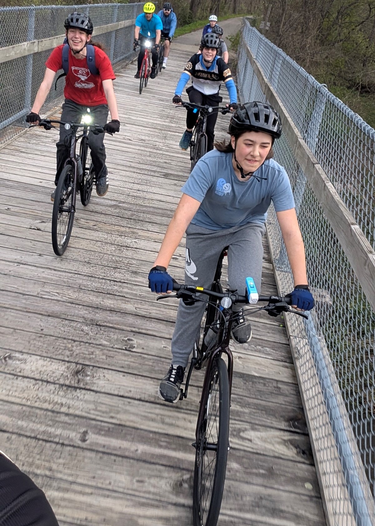 Young bikers biking over bridge