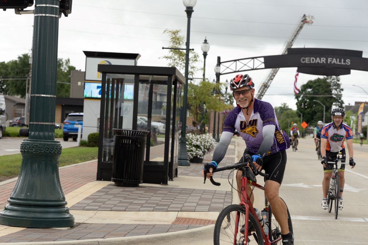 RAGBRAI rider wearing UNI jersey entering Cedar Falls downtown district