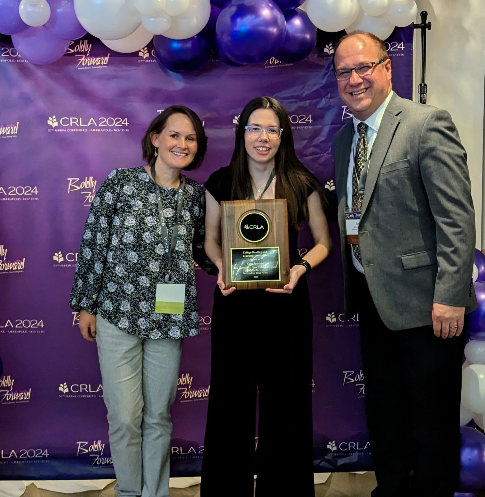 Sara Petersen with award, standing next to Heather Asmus and John Ophus