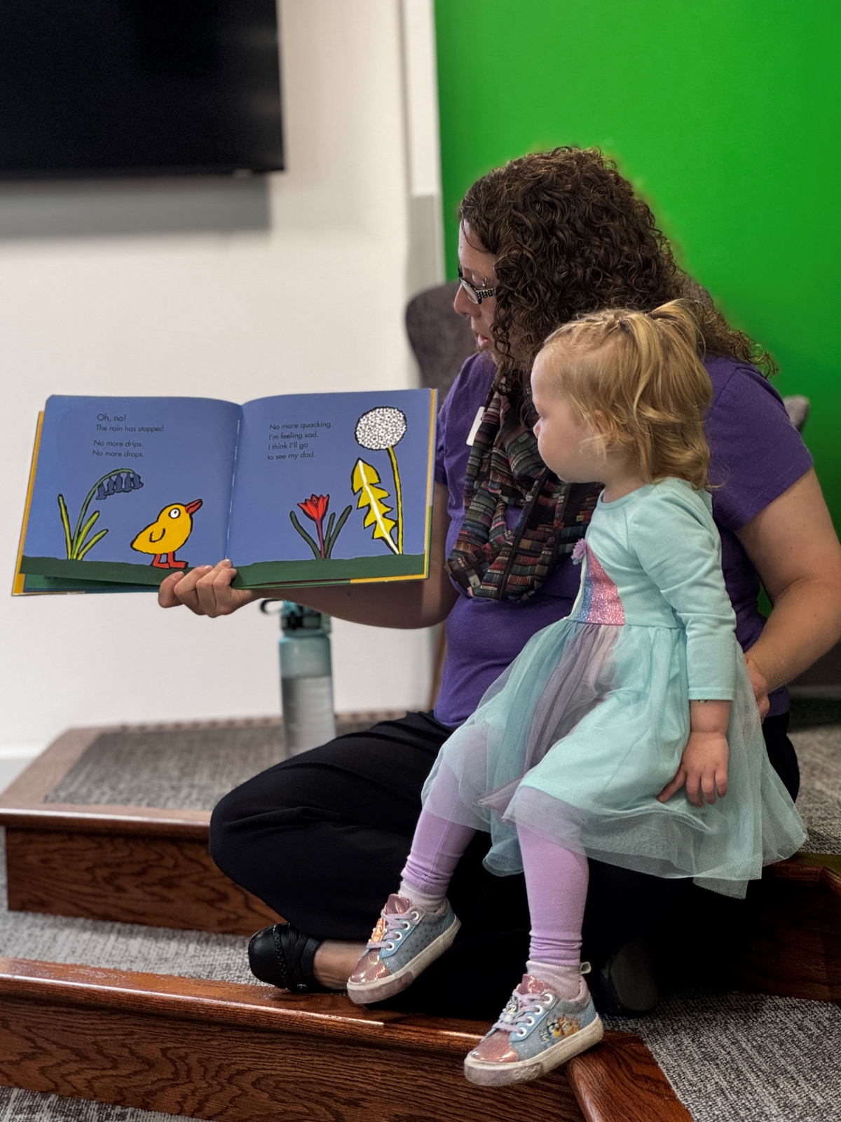 Katie Nedwick reading a book to a young child