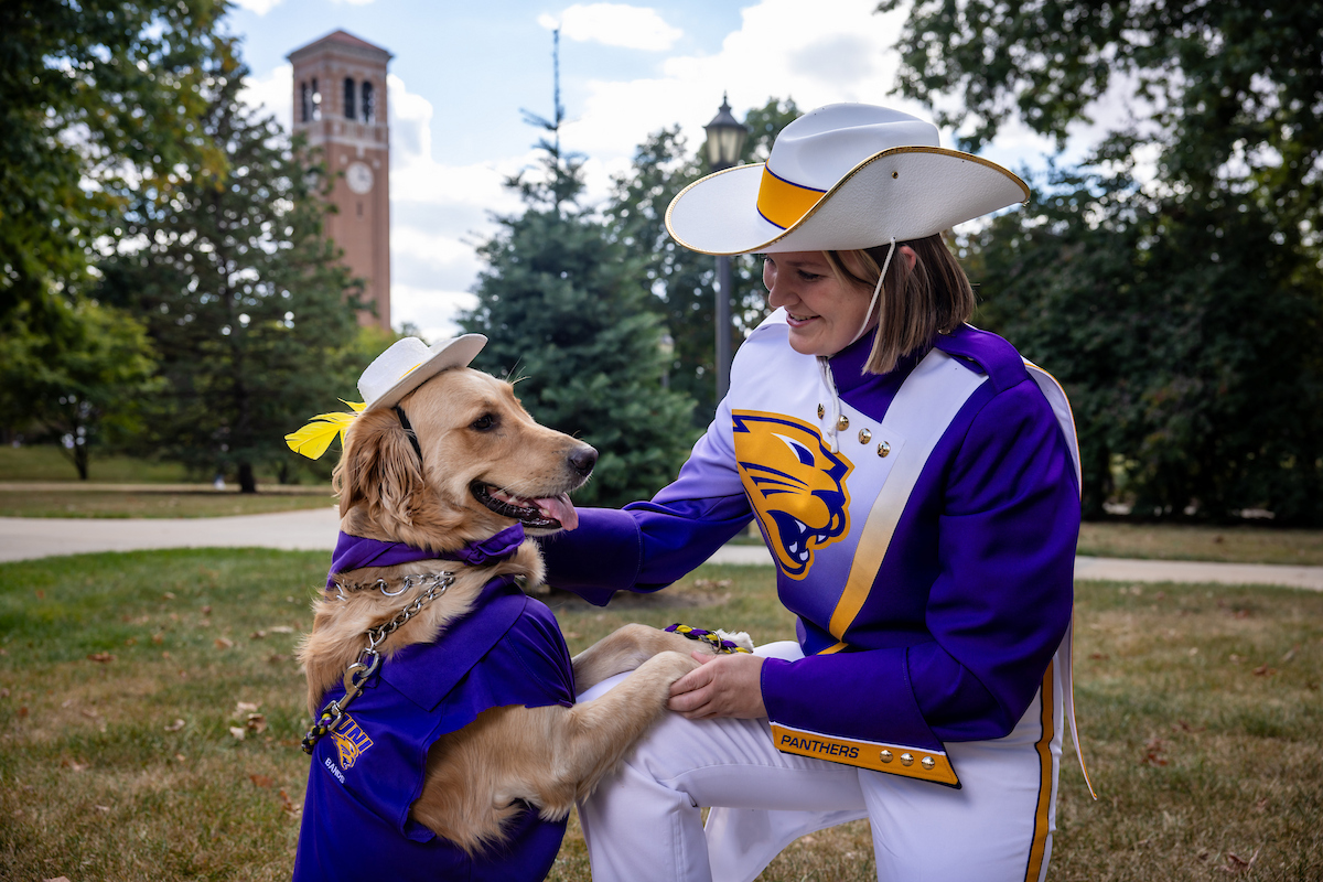 Gabi Riessen and service dog Winnie in Panther Marching Band gear