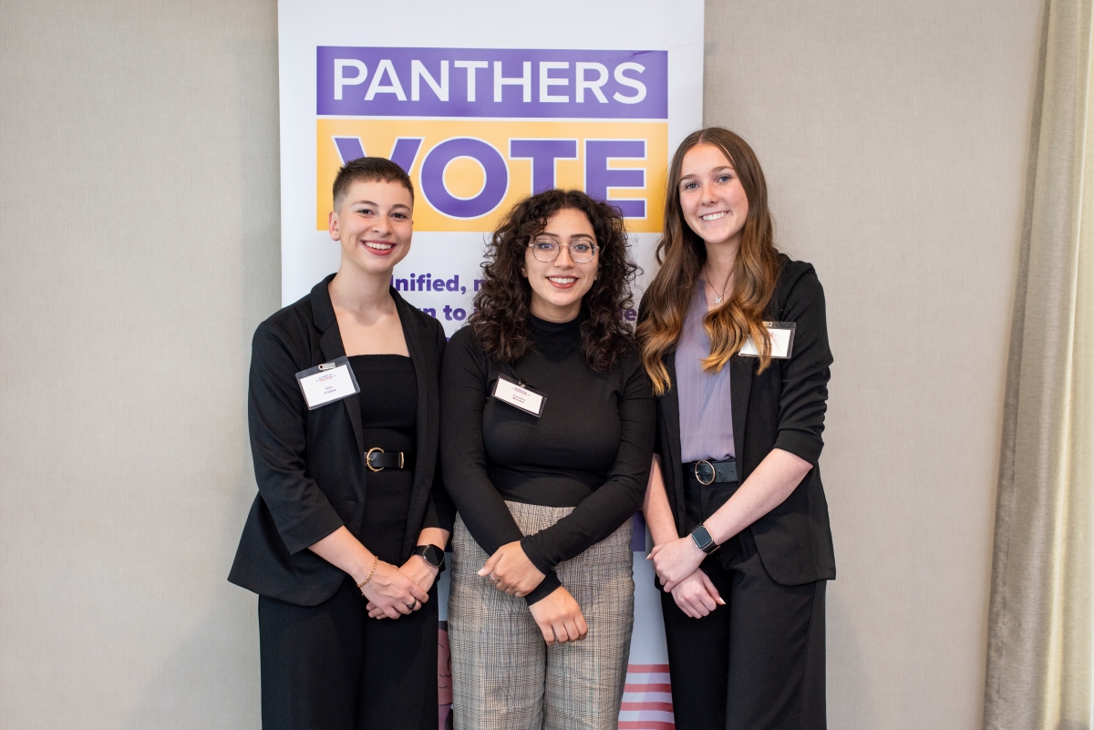 Women in Politics scholarship recipients in front of Panthers Vote sign